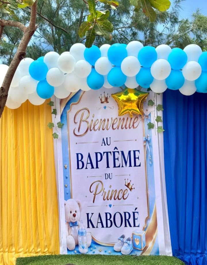 Décor de baptême avec arche de ballons bleus et blancs, rideaux et panneau de bienvenue