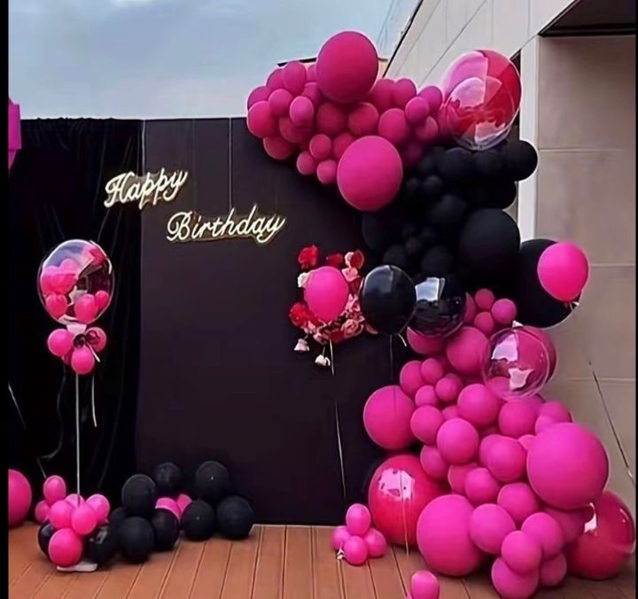 Décor d'anniversaire avec ballons roses et noirs et lettres dorées