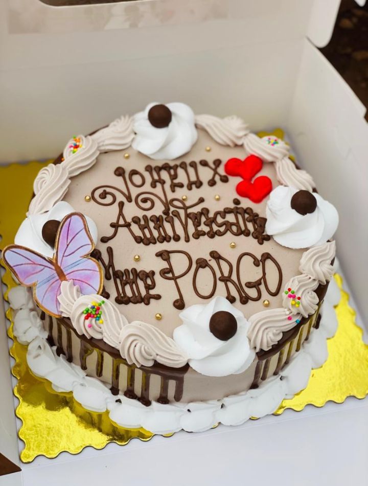 Gâteau d'anniversaire au chocolat avec papillon, cœurs rouges et crème